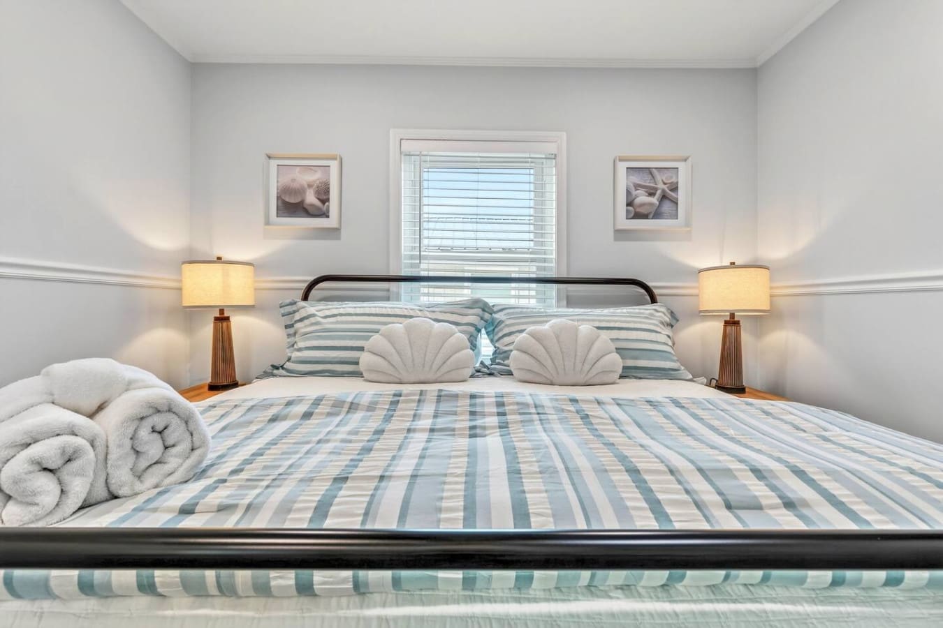Wake up to natural light and ocean views in this serene coastal-inspired bedroom with crisp linens and warm ambient lighting.