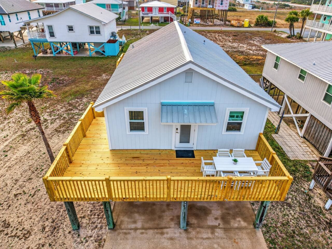 This charming elevated beach cottage features a spacious wooden deck with ocean views and direct beach access.