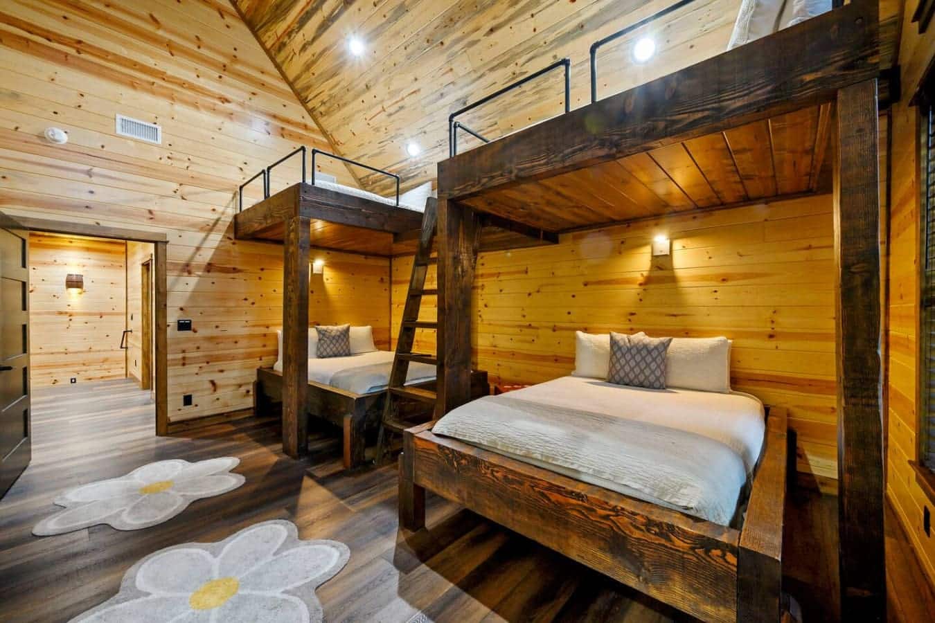 This cozy cabin bedroom features two gorgeous dark wood canopy beds with plenty of space for a group getaway.