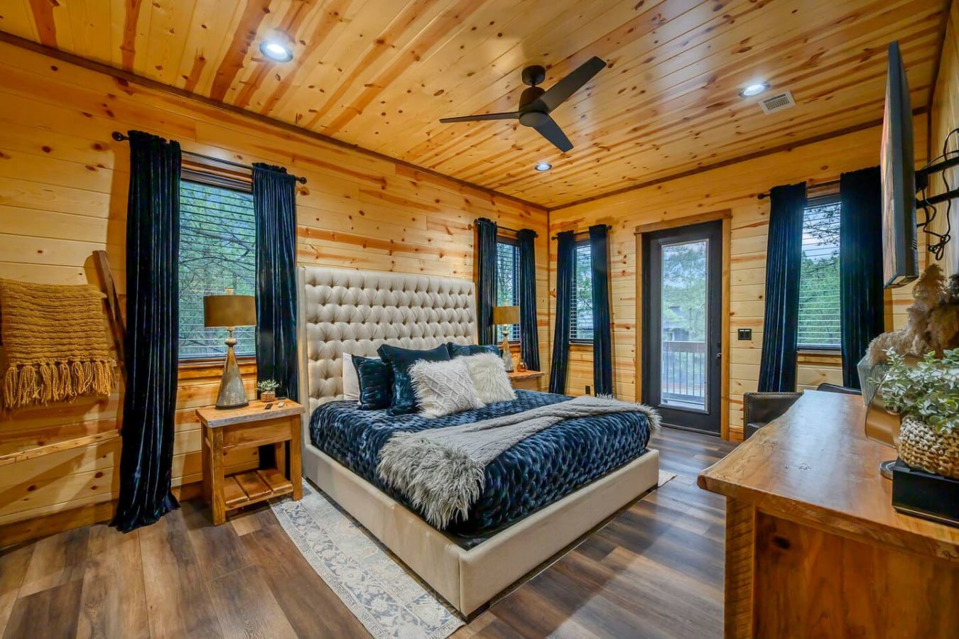This luxe log cabin master suite has everythingu2014soaring wood ceilings, multiple glass doors opening to views, and a statement bed that screams relaxation.