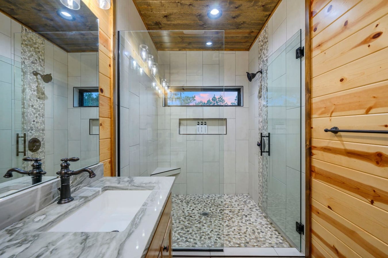 This spa-like primary bath features a spacious walk-in shower with a view and heated floors.