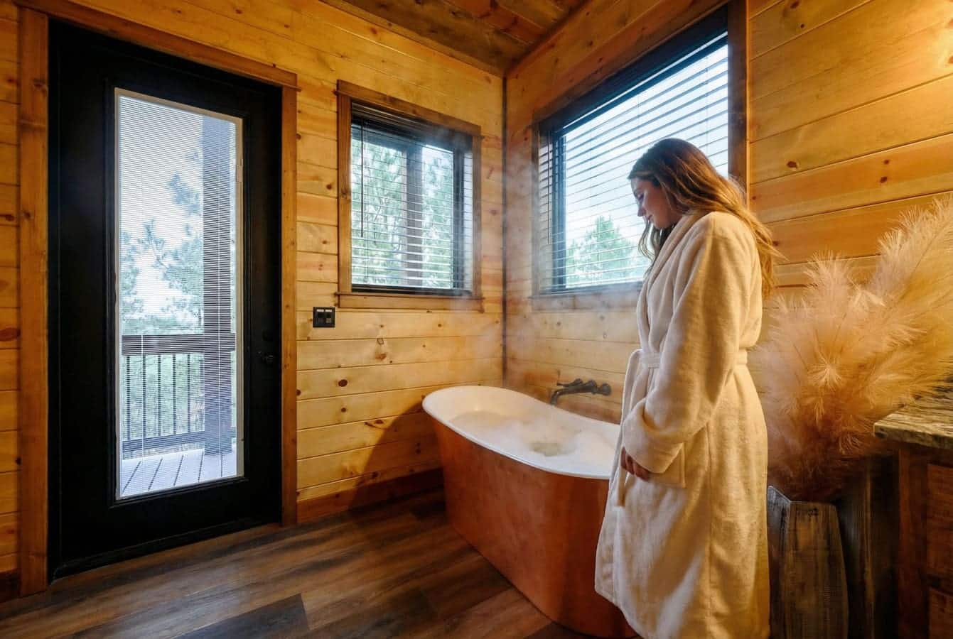 Wake up in this dreamy wooden soaking tub with views of the forest from every window.