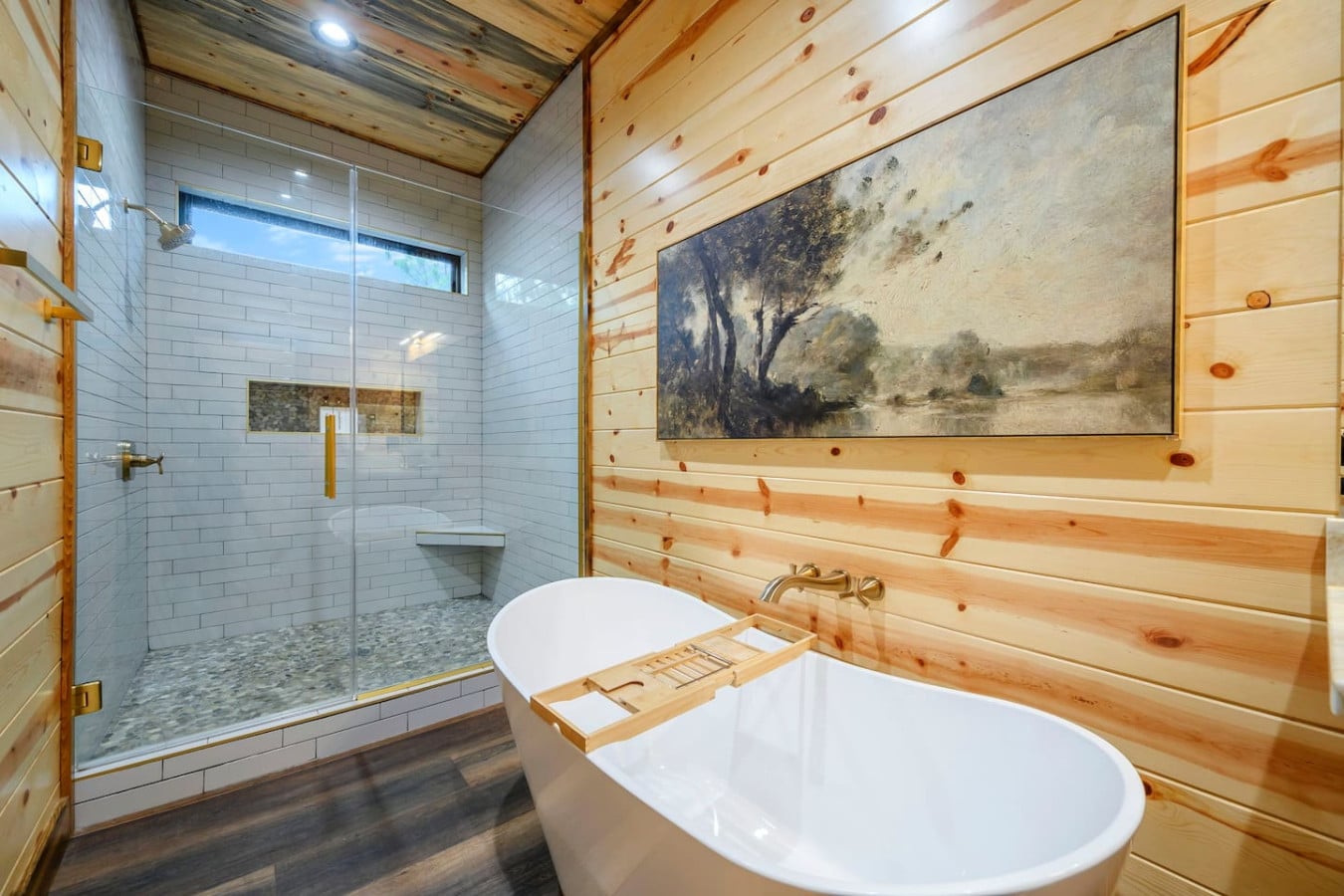 This spa-like primary bath features a soaking tub, walk-in shower, and rustic wood walls that'll make you never want to leave.