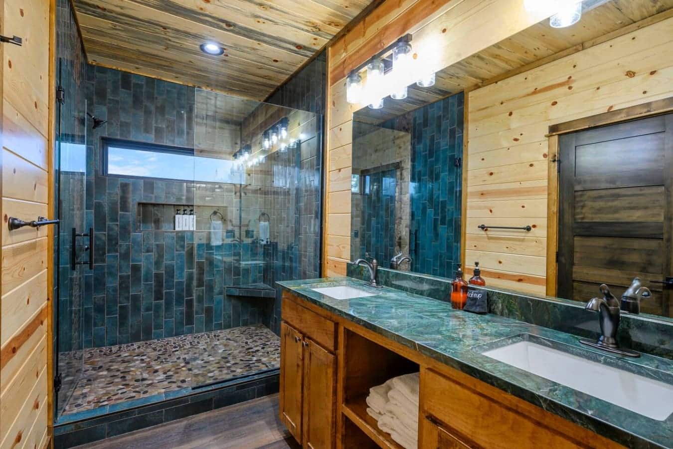 This spa-like master bath features slate tile, a spacious walk-in shower, and a stunning green marble double vanity.