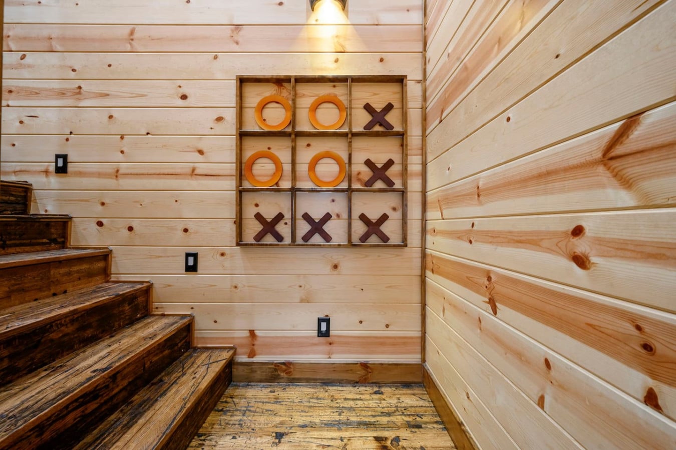 This cozy cabin game room features a giant tic-tac-toe board perfect for some friendly competition between guests.