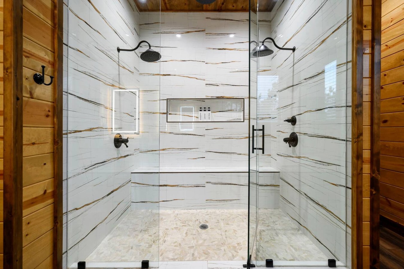 This spa-like walk-in shower with heated floors and dual rainfall showerheads is basically a luxury hotel experience in your own bathroom.