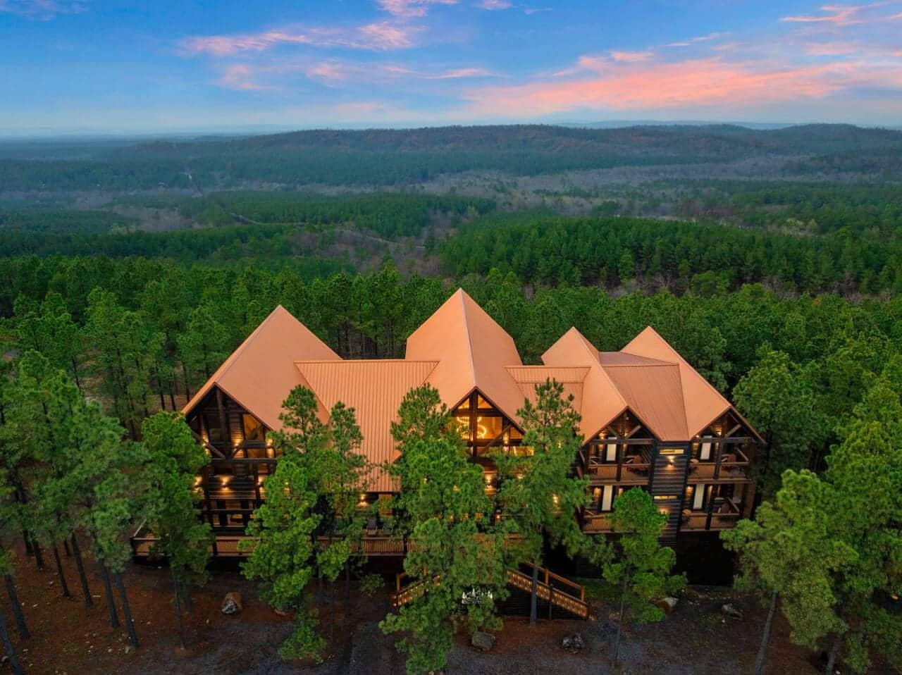 This stunning log mansion sits nestled in towering pines with incredible forested valley views stretching for miles.