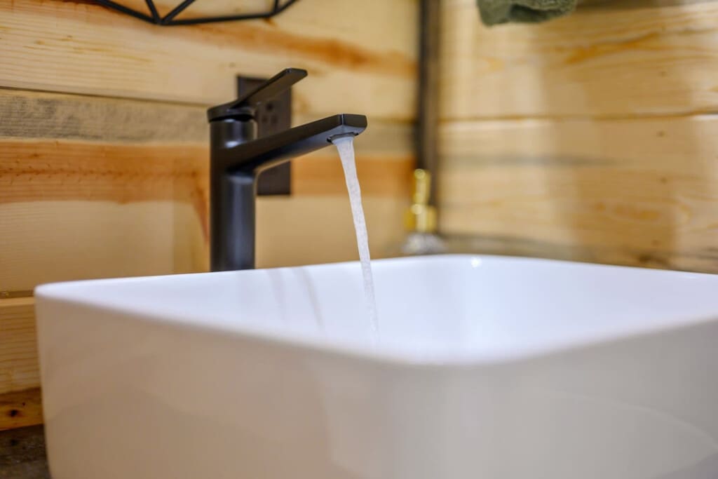 The sleek black faucet flowing into this crisp white vessel sink is basically the perfect modern touch to make your cabin bathroom feel like a little spa retreat.