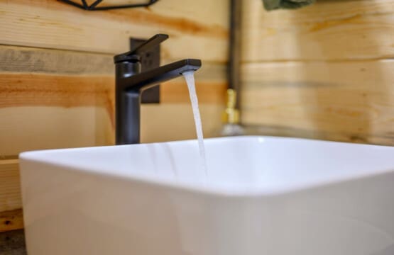 The sleek black faucet flowing into this crisp white vessel sink is basically the perfect modern touch to make your cabin bathroom feel like a little spa retreat.