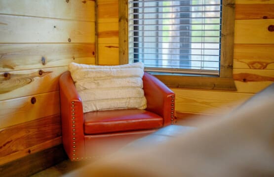 This cozy nook tucked into the log cabin is basically the perfect spot to curl up with a book and watch the light filter through those cabin windows.