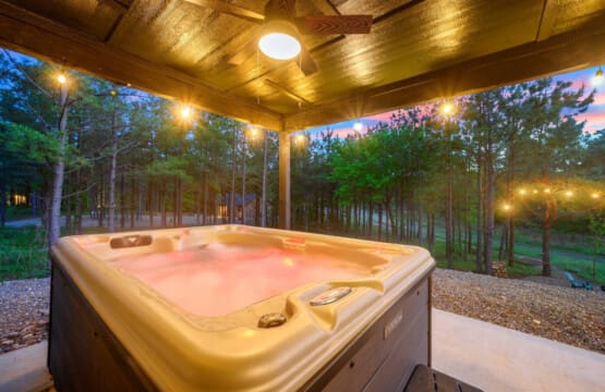 There's something seriously special about soaking in a hot tub under a covered patio as the forest fades into twilight and those warm lights make everything feel like your own private escape.