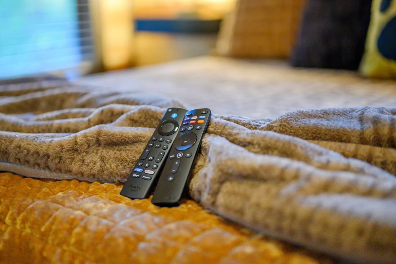 Grab your remotes and get cozy—nothing says "vacation mode activated" like two different controllers ready to go on a plush cabin bed.
