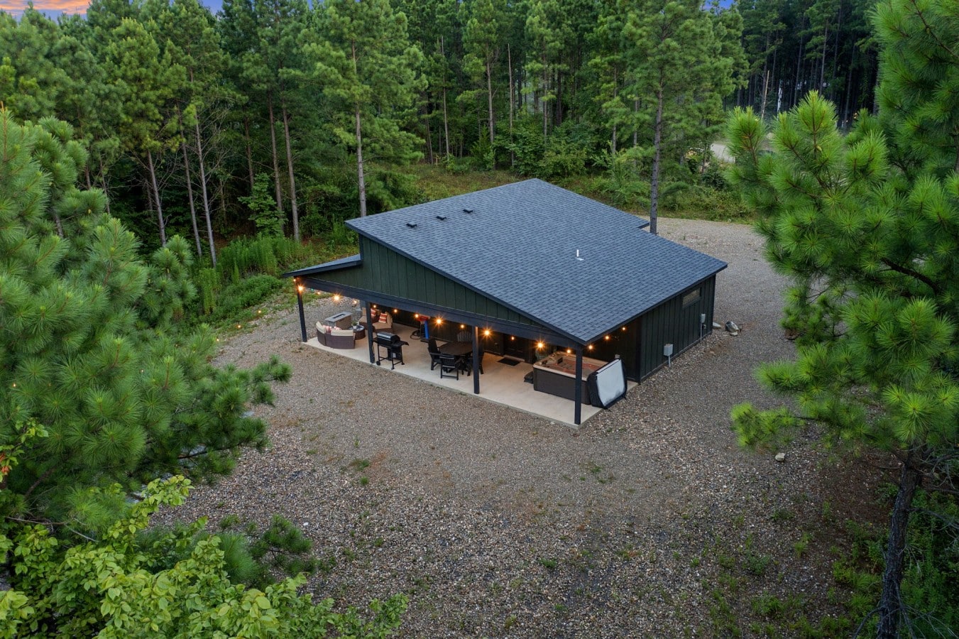 High drone view showing the cabin's secluded setting among the trees.