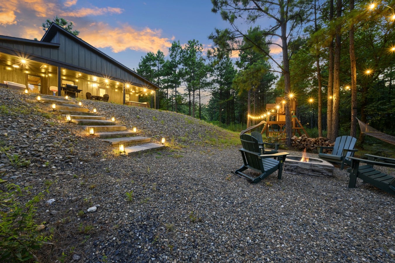 Gravel path and landscape lighting leading toward the cabin's outdoor spaces.