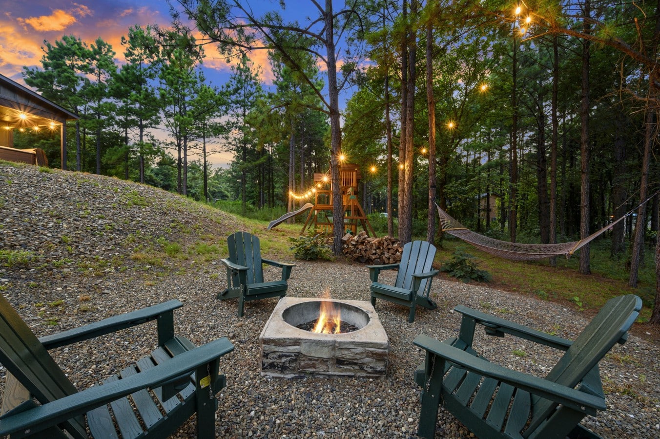 Fire pit seating arranged in a private wooded corner of the property.