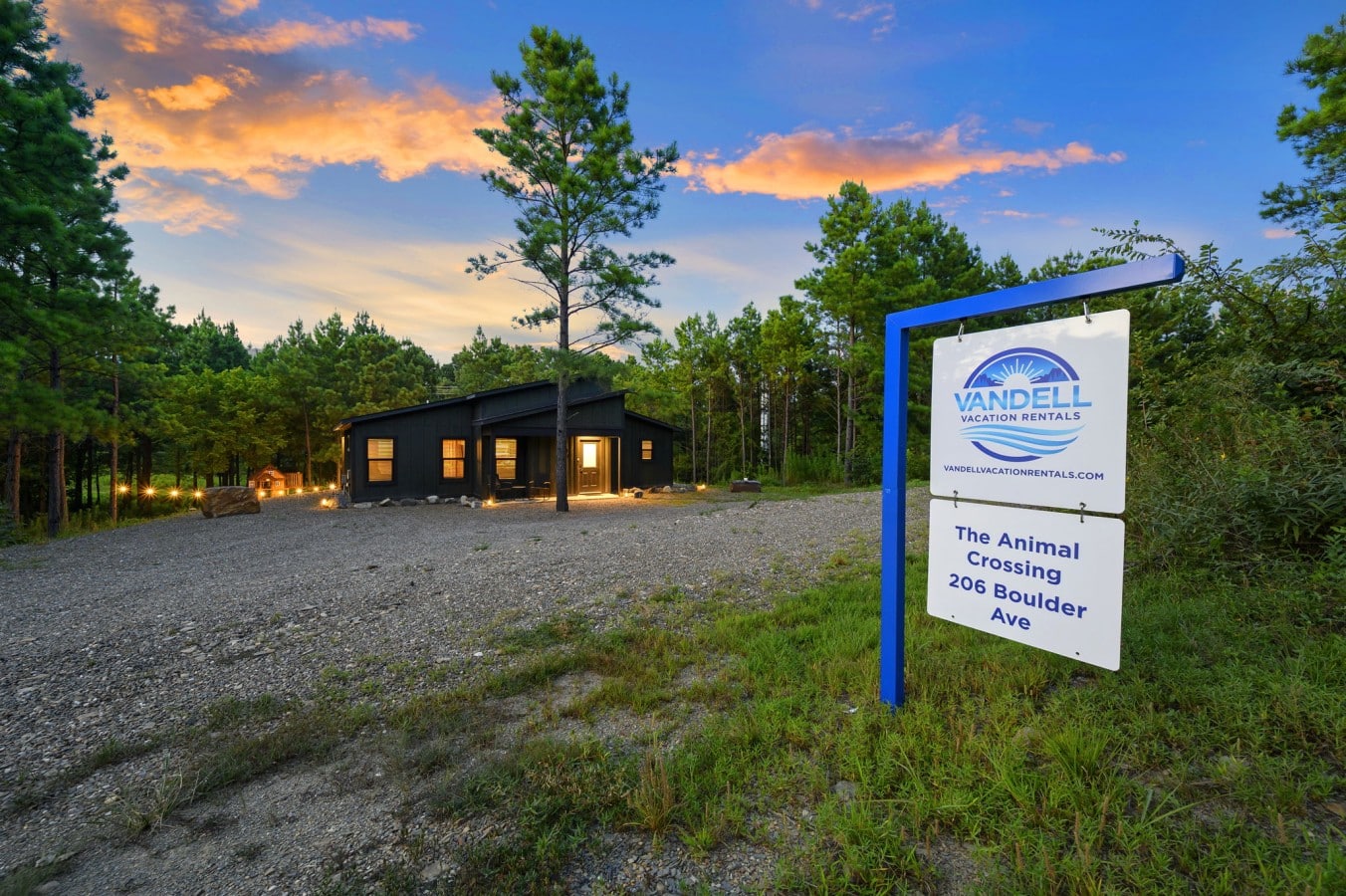 Wide exterior view of The Animal Crossing at sunset with sign and cabin.