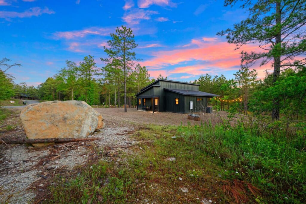 Watch this sleek modern cabin come alive as the sun sets, casting that perfect glow across the clearing while the forest stays still and quiet all around you.