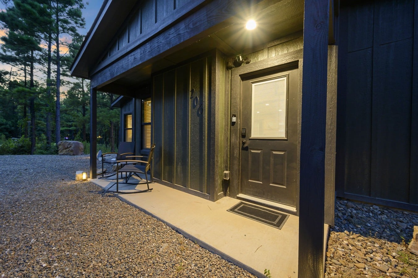 Front entry and covered porch with warm lighting at dusk.