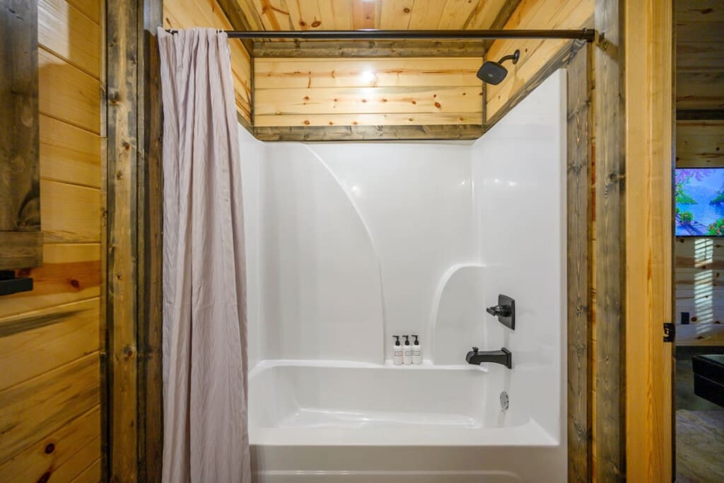 This spa-like bathroom setup with the overhead rainfall showerhead and wooden beams is basically the perfect way to wash off the day after exploring the forest.