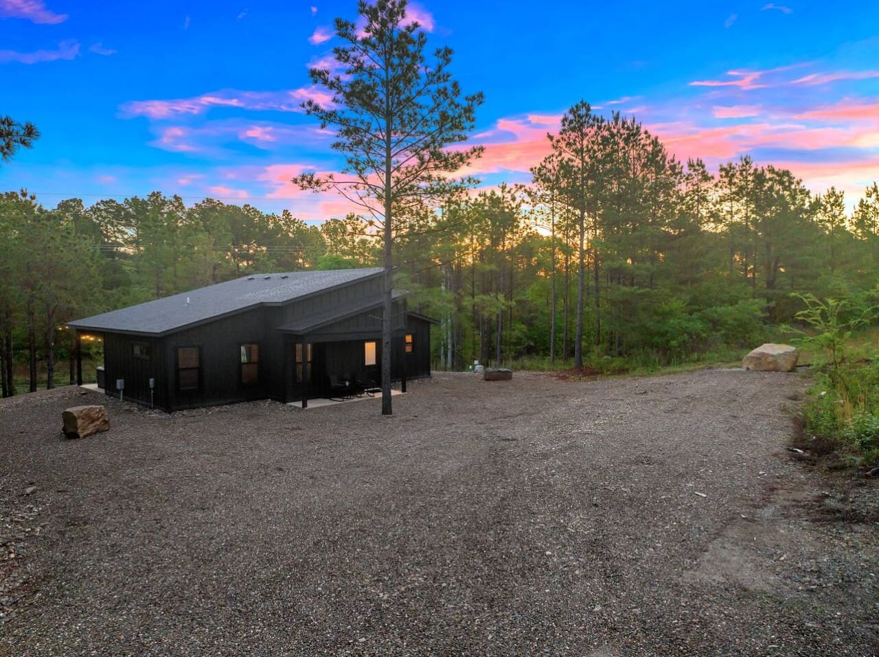 This sleek modern black cabin tucked into the forest feels like stepping into your own private retreat, especially with that stunning twilight sky lighting everything up just right.