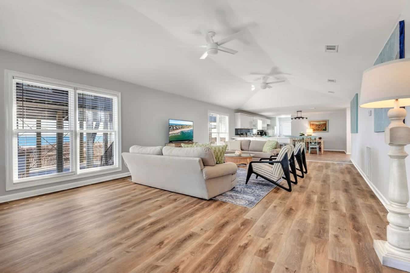 This open-concept beachfront home is basically built for lounging—huge windows frame those ocean views, multiple ceiling fans keep the breeze flowing, and you've got plenty of space to spread out and actually relax.