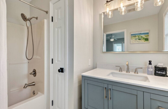 This sparkling master bath with its dual vanities, soft lighting, and serene coastal vibes is basically your personal spa—the perfect spot to wash off the sand and start or end each day feeling refreshed.