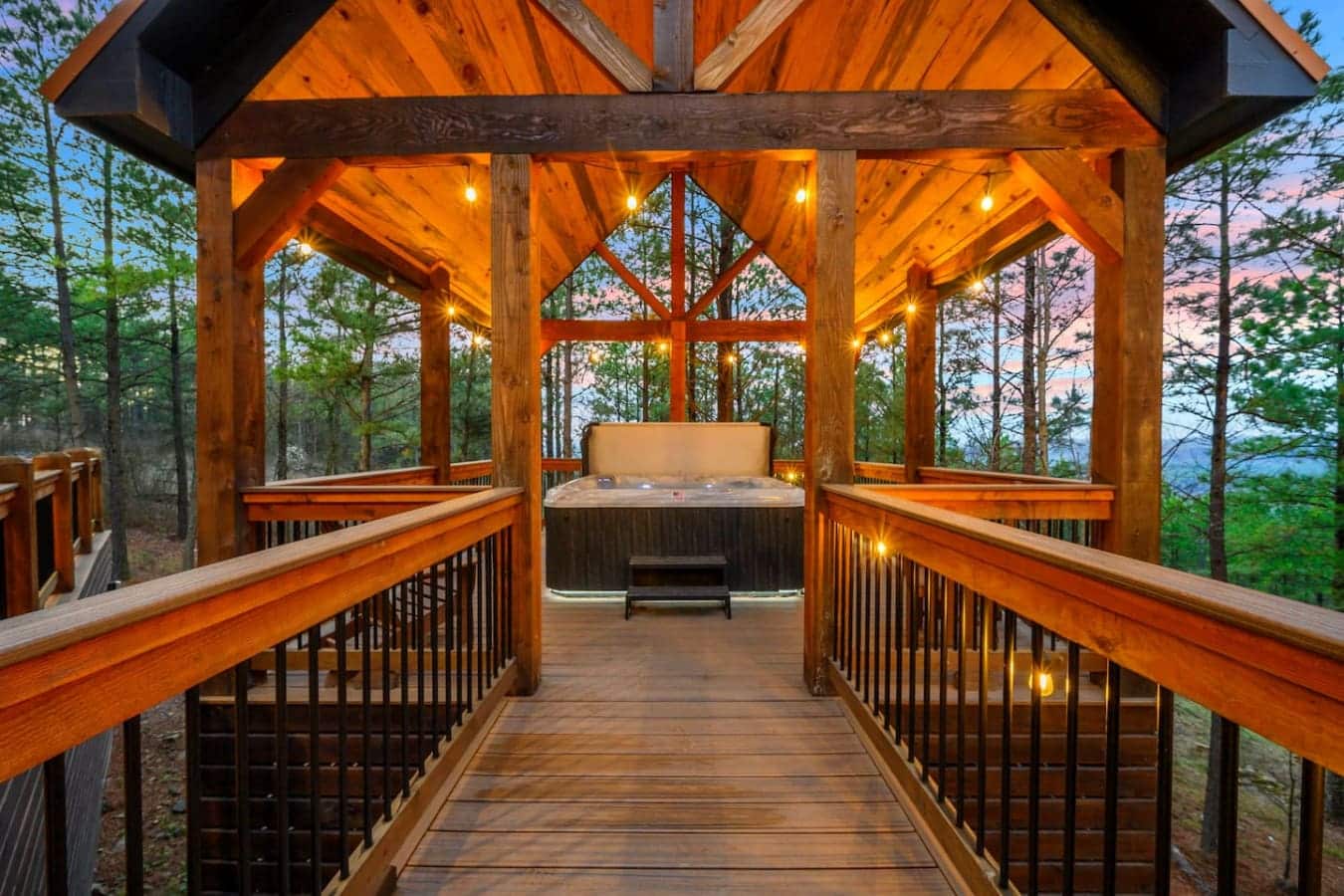 This stunning timber-framed hot tub gazebo overlooks the forest with ambient lighting and endless mountain views.