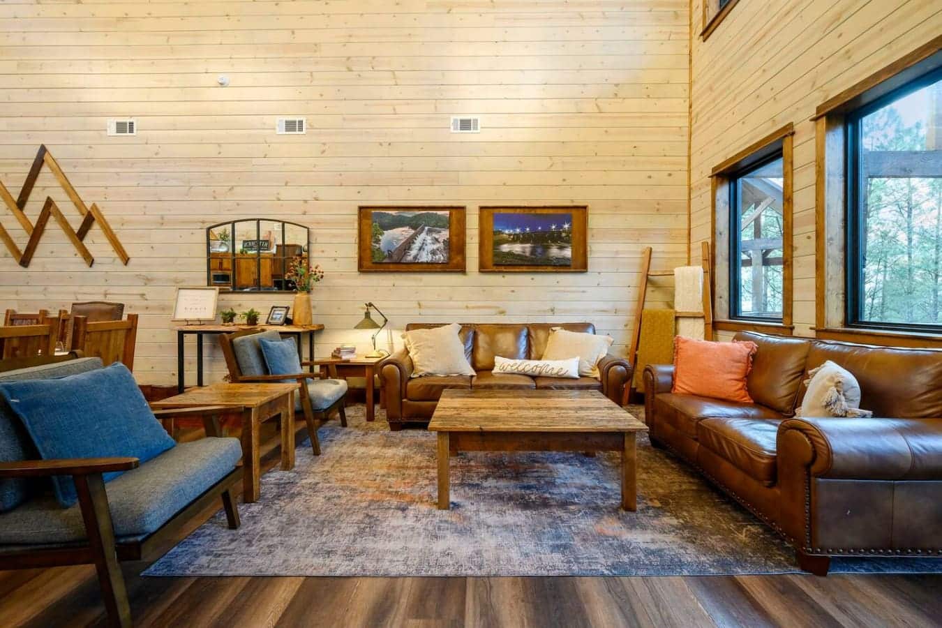 Cozy living room with leather seating, wood beams, and plenty of natural light from those huge windows.