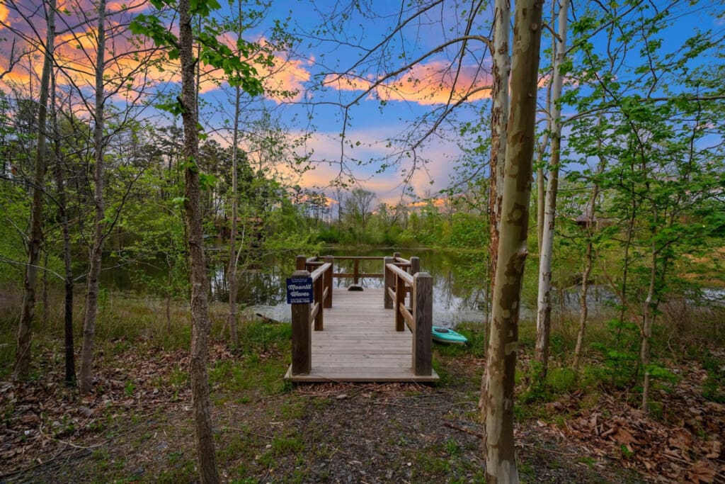 This inviting cabin deck offers peaceful views of the tranquil pond.