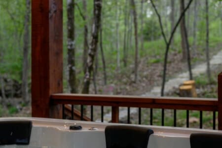 This inviting cabin deck offers peaceful views of the tranquil pond.