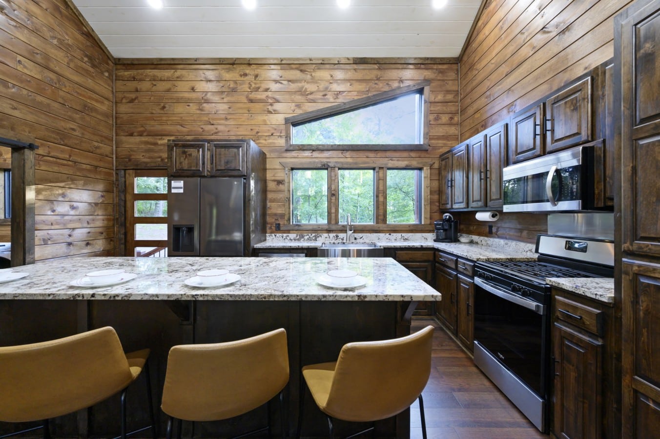Cook together in a fully equipped kitchen where natural light pours through forest views.
