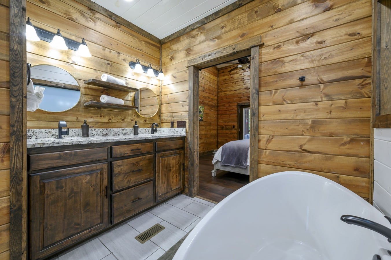 Knotty pine walls and a freestanding tub give this master bath its own quiet luxury.