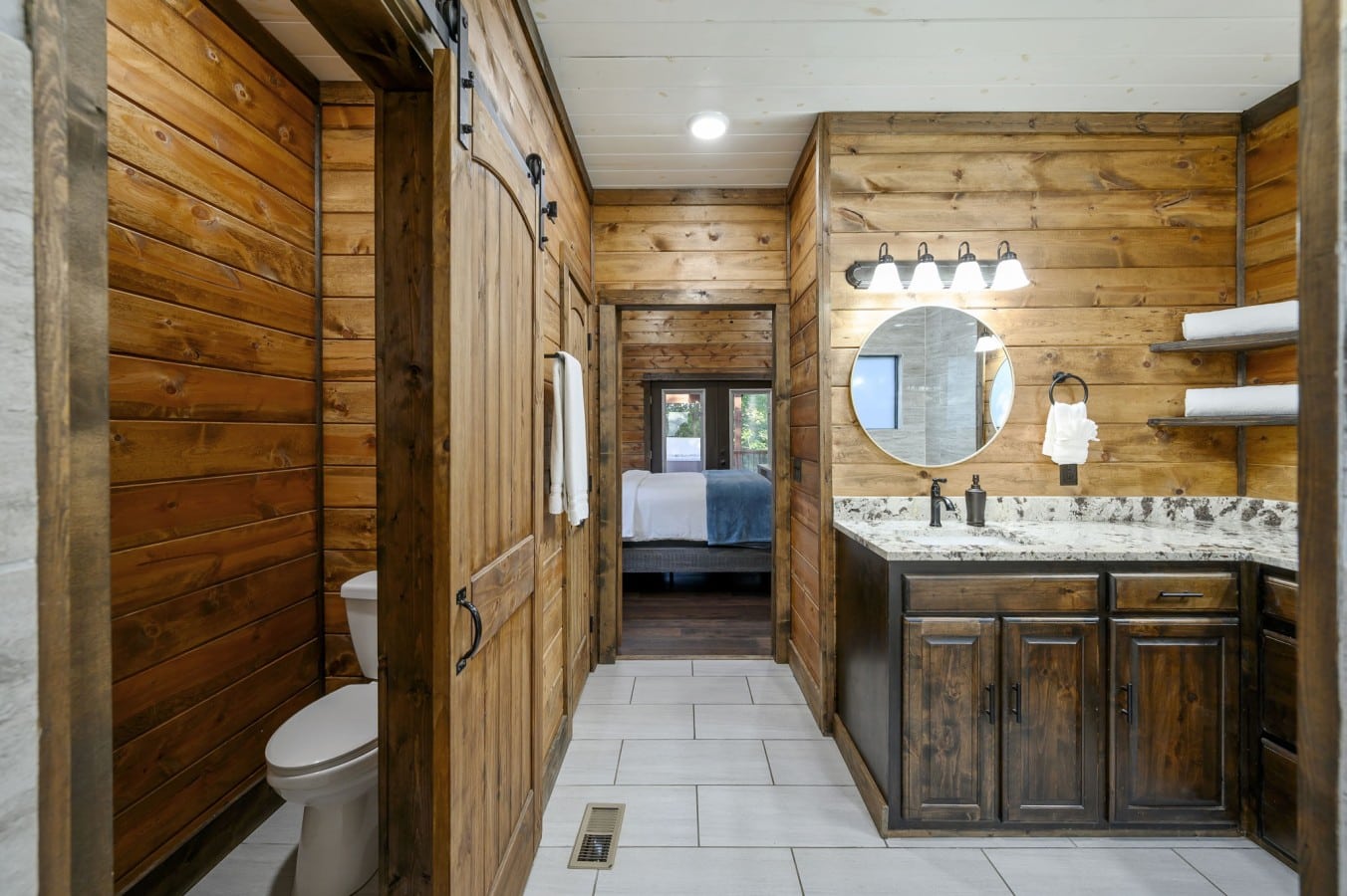 Shiplap walls and a barn door give this charming bath a warm, cabin-perfect personality.