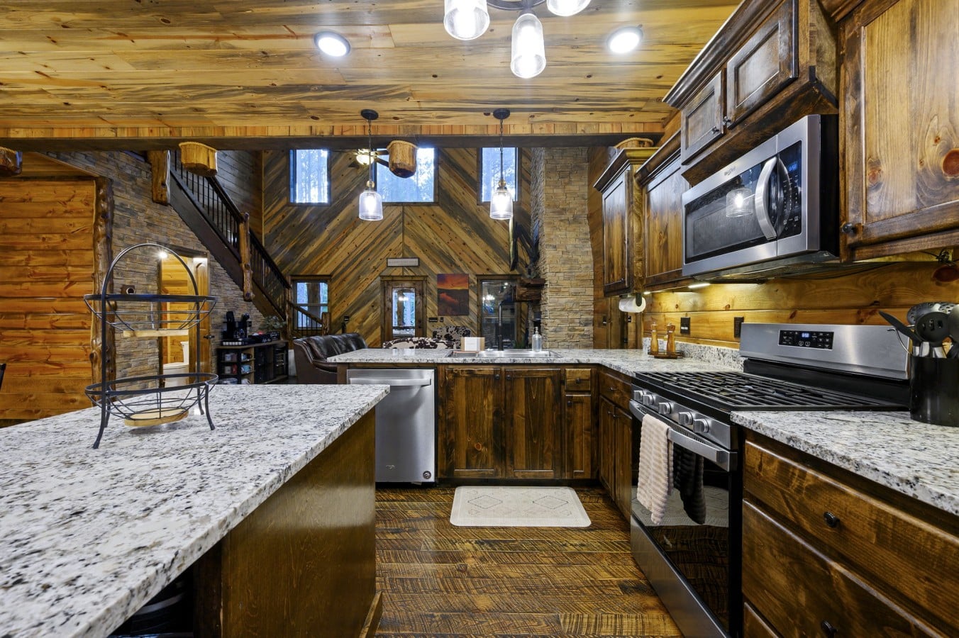 Cook with a view u2014 the kitchen looks straight into the dramatic great room and its soaring stone fireplace.