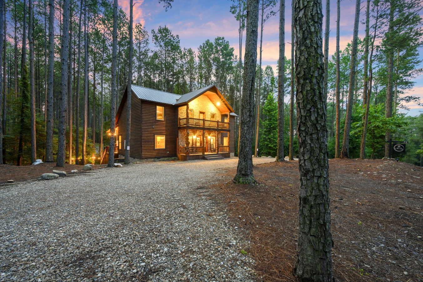 A dramatic twilight sky frames your private log-and-stone retreat in pure mountain magic.