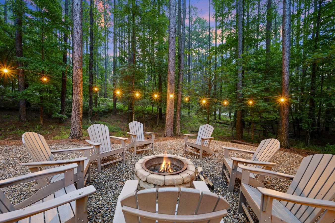 Adirondack chairs, a stone fire pit, and Edison lights turn any night into a cherished memory.