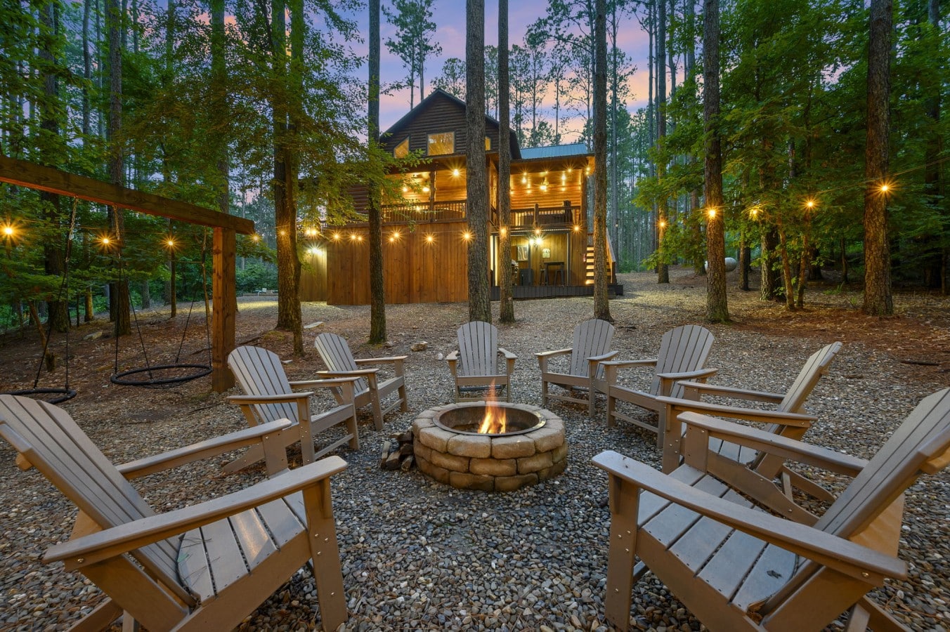 A stone fire pit, string lights, and a glowing cabin u2014 this is mountain magic made real.