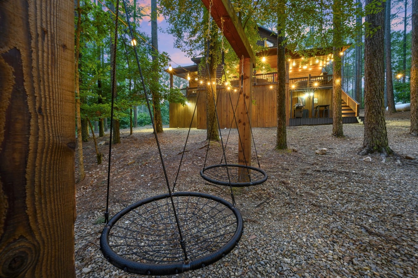 Swing in the oversized nest chairs while Edison lights flicker through the pines above you.