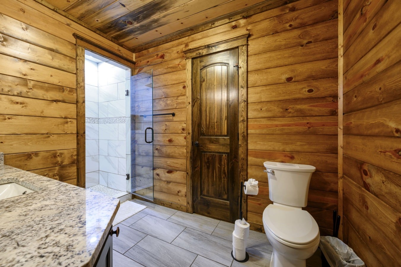 A clean, glass-enclosed shower and granite vanity keep every guest comfortable and refreshed.