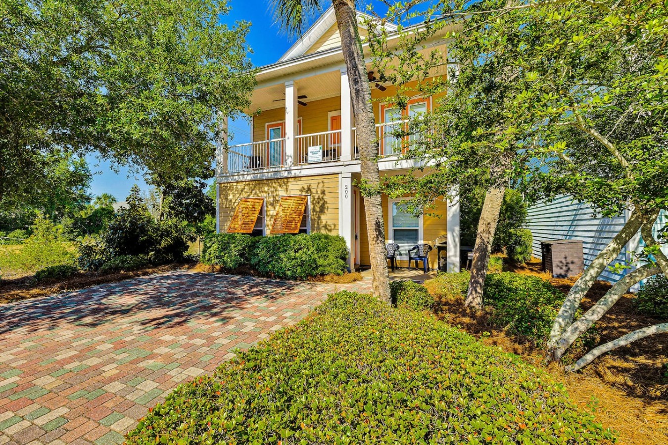 Louvered shutters and blooming greenery give this porch its irresistible island character.