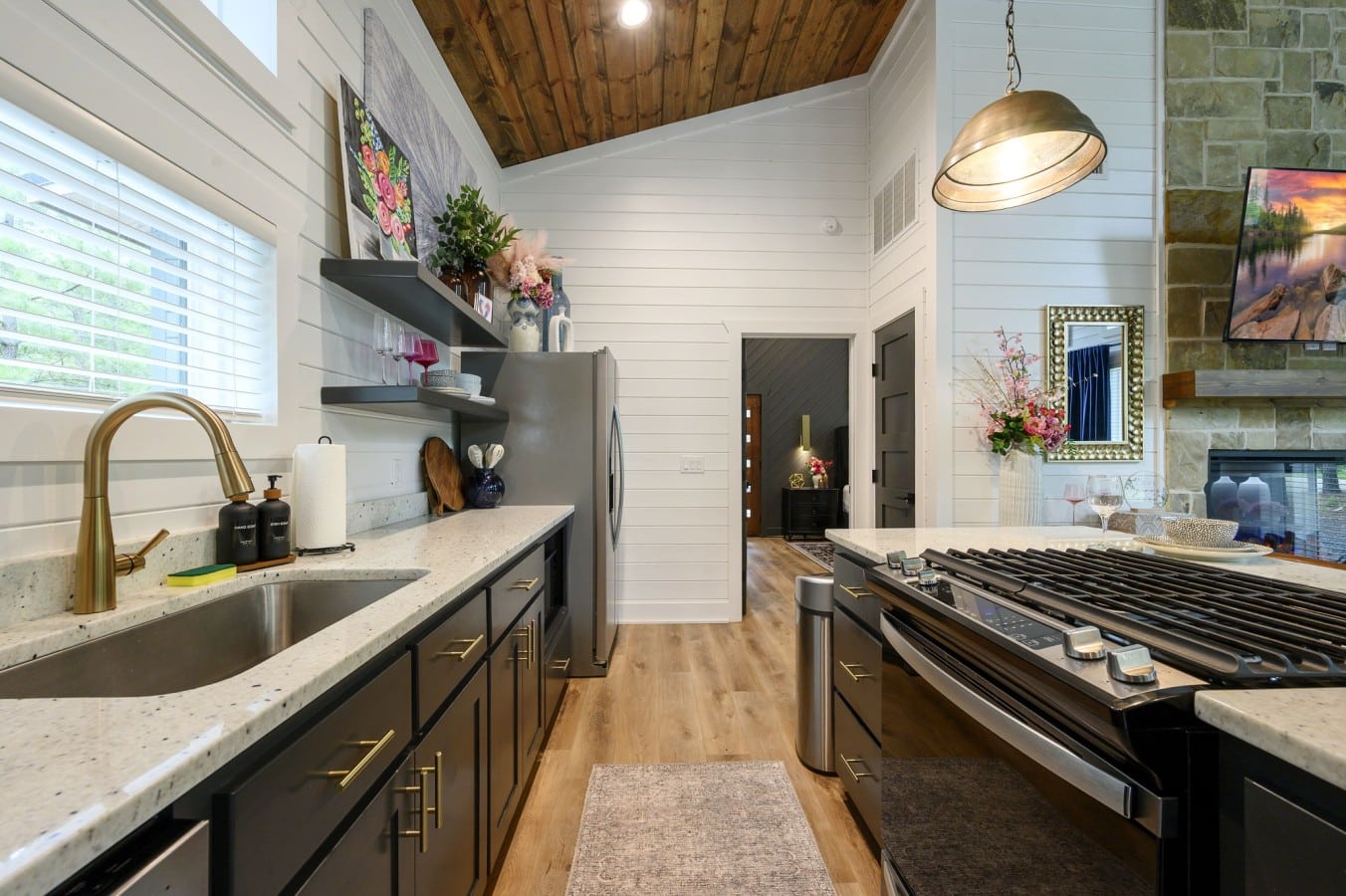 Brass fixtures and quartz counters give the kitchen an effortlessly upscale feel.