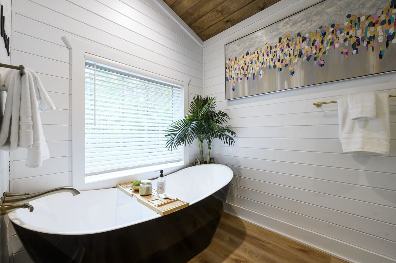 A black soaking tub beneath a vaulted ceiling turns bath time into pure indulgence.