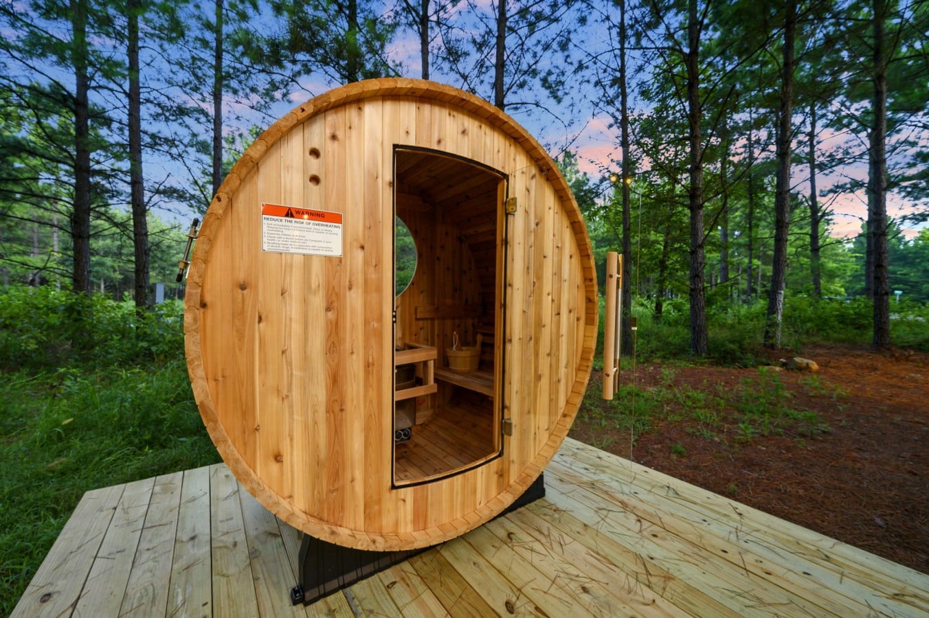Barrel sauna exterior with wooded privacy all around.