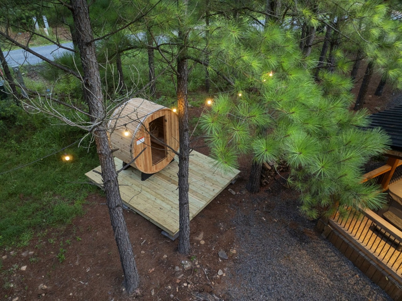 Aerial view of the sauna deck and fire pit tucked beside the cabin.