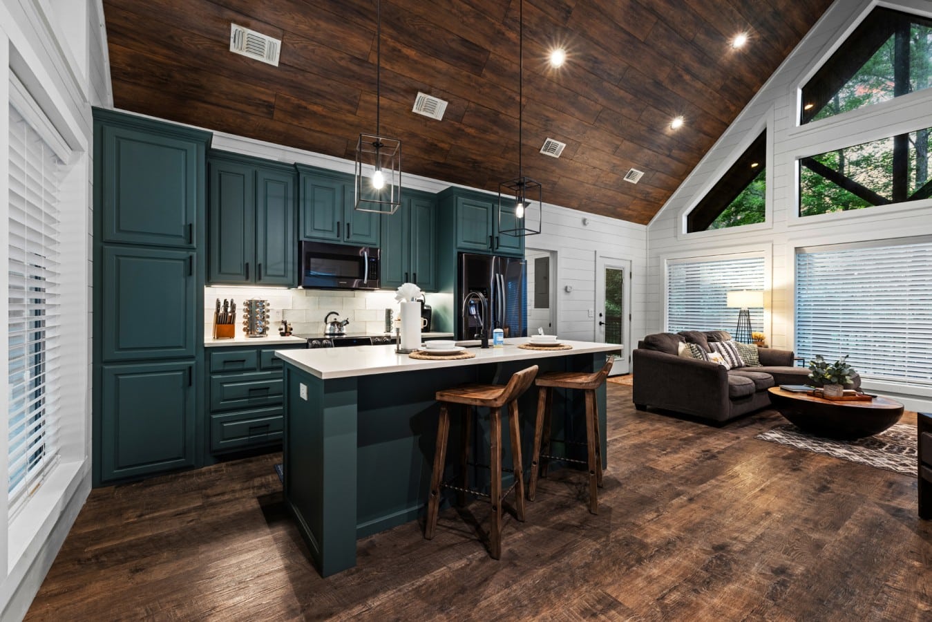 Kitchen and living room flow together beneath the wood ceiling.