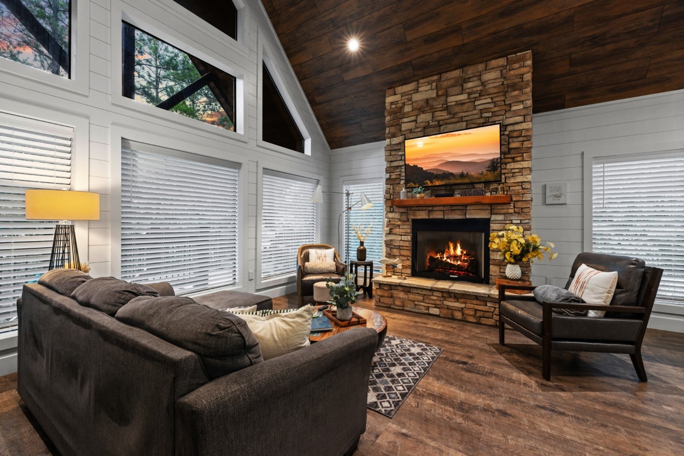 Vaulted living room with fireplace, mountain art, and natural light.