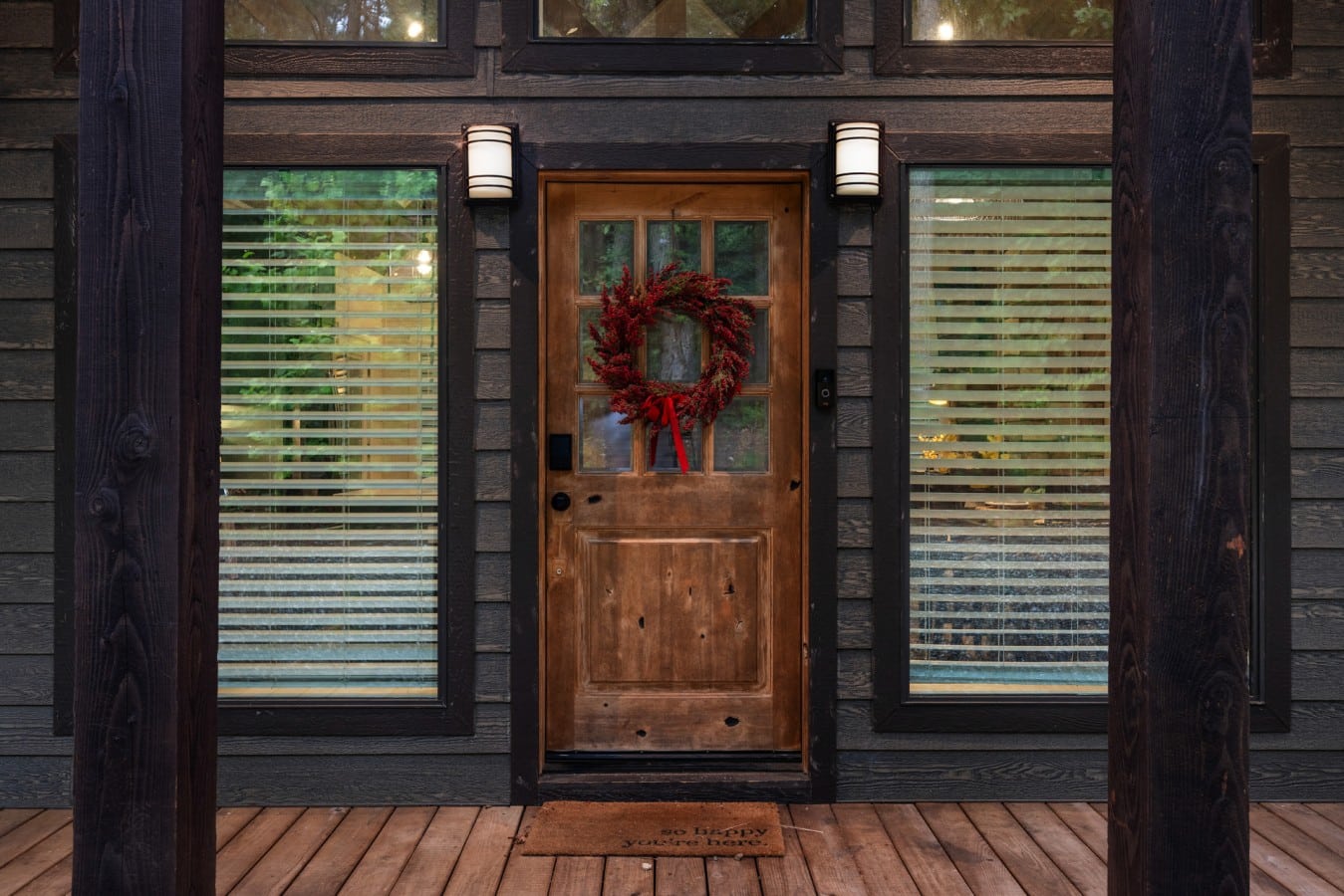 Front door detail with warm wood and covered entry lighting.
