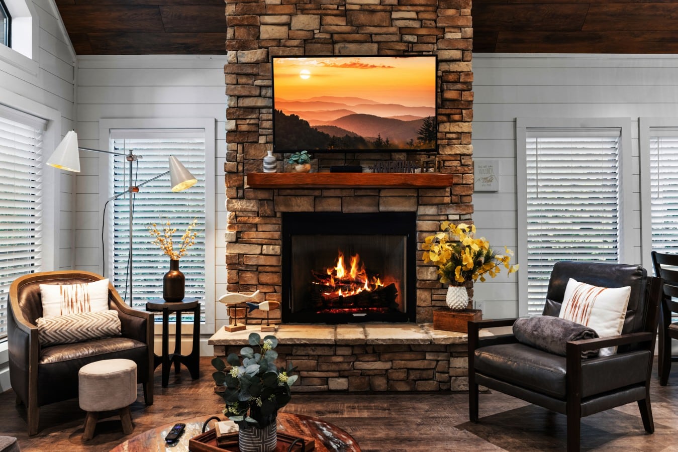 Living room fireplace detail with warm cabin texture and decor.