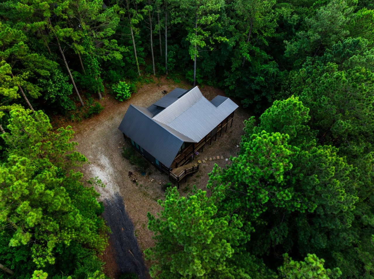 Driveway and roofline from above, showing the secluded cabin lot.
