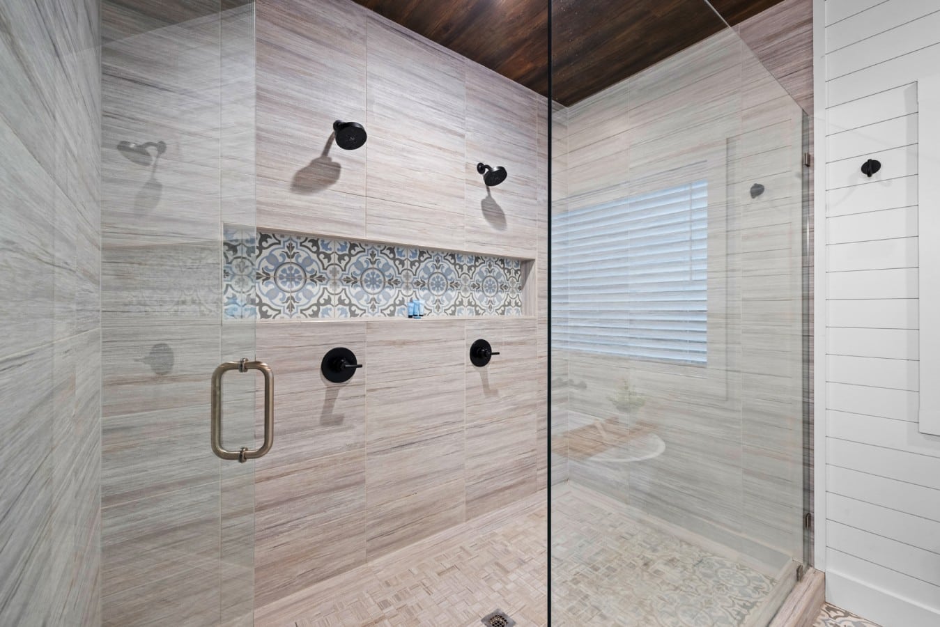 Walk-in shower with bench, rain head, and detailed tile work.